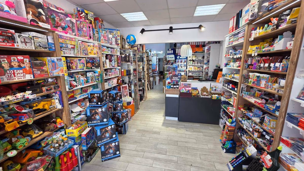 Unutrašnjost knjižare sa policama punim knjiga, poklona i školskog pribora